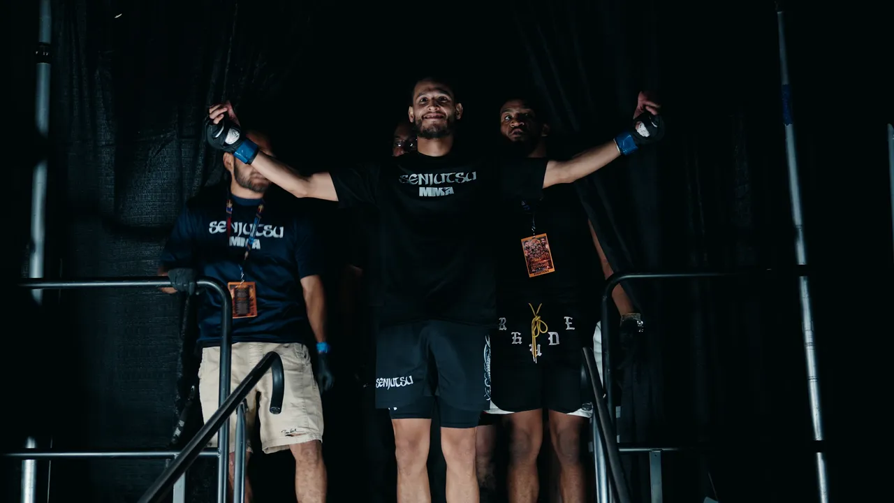 EJ Hernandez with arms wide at the entrance curtain, his corner beside him